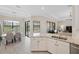A modern kitchen with stainless appliances, granite counters, and open dining area with outdoor views at 20443 Cristoforo Pl, Venice, FL 34293
