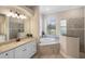 Bathroom features dual sinks, tub, and walk-in glass shower at 20443 Cristoforo Pl, Venice, FL 34293