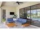 Covered patio features comfortable blue lounge seating, and a ceiling fan at 20443 Cristoforo Pl, Venice, FL 34293