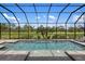Screened pool with water feature, with a view of greenery beyond the enclosure at 20443 Cristoforo Pl, Venice, FL 34293