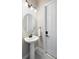 Clean powder room with a pedestal sink and a white door at 20443 Cristoforo Pl, Venice, FL 34293