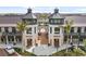 View of shops with outdoor seating areas, palm trees, and visible storefronts at 20443 Cristoforo Pl, Venice, FL 34293
