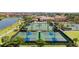 Aerial view of a tennis and pickleball court area showing well-maintained courts and surrounding landscape at 20443 Cristoforo Pl, Venice, FL 34293