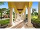 A covered walkway showcases elegant columns, tile flooring, and a view of the community playground at 20443 Cristoforo Pl, Venice, FL 34293