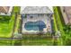 Bird's-eye view of the screened-in pool, spa, and backyard area offering privacy and surrounded by green grass at 20749 Swallowtail Ct, Venice, FL 34293