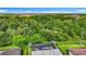 An aerial view of the backyard showing the screened-in pool and spa surrounded by lush green landscaping at 20749 Swallowtail Ct, Venice, FL 34293
