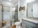 Modern bathroom with glass shower, gray tile, granite countertop and decorative shelving at 20749 Swallowtail Ct, Venice, FL 34293