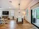 Dining room features a modern chandelier, hardwood floors, and sliding door to backyard at 20749 Swallowtail Ct, Venice, FL 34293