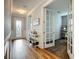 Inviting hallway with hardwood floors, decorative wainscoting and french doors to office at 20749 Swallowtail Ct, Venice, FL 34293