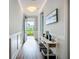 Hallway with a decorative table and a view of the front yard through the glass door at 20749 Swallowtail Ct, Venice, FL 34293