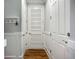Hallway with stylish doors, decorative wainscoting, wood floors, and convenient wall hooks for coats and keys at 20749 Swallowtail Ct, Venice, FL 34293