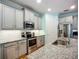 Modern kitchen features stainless steel appliances, granite counters, and stylish gray cabinetry at 20749 Swallowtail Ct, Venice, FL 34293