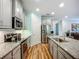 Modern kitchen with stainless steel appliances, gray cabinets, and granite countertops at 20749 Swallowtail Ct, Venice, FL 34293
