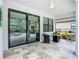 Covered lanai with neutral stone tile flooring, comfortable seating, and an outdoor grill for relaxed entertaining at 20749 Swallowtail Ct, Venice, FL 34293