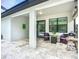 Covered lanai with neutral stone tile flooring, comfortable seating, and an outdoor grill for relaxed entertaining at 20749 Swallowtail Ct, Venice, FL 34293