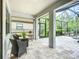 Covered lanai with neutral stone tile flooring, comfortable seating, and an outdoor grill for relaxed entertaining at 20749 Swallowtail Ct, Venice, FL 34293