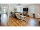 Bright living room with hardwood floors, comfortable seating, and modern entertainment center at 20749 Swallowtail Ct, Venice, FL 34293