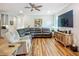 Bright living room with hardwood floors, comfortable seating, and modern entertainment center at 20749 Swallowtail Ct, Venice, FL 34293