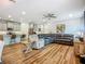 Open living area with kitchen view, hardwood floors, and comfortable sectional seating at 20749 Swallowtail Ct, Venice, FL 34293