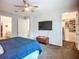 Bright main bedroom features a ceiling fan, TV, and walk-in closet for ample storage at 20749 Swallowtail Ct, Venice, FL 34293