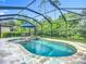 Screened-in pool and spa with travertine tile decking, outdoor seating, and beautiful landscaping offering privacy at 20749 Swallowtail Ct, Venice, FL 34293