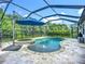 Screened pool area featuring a sparkling pool with a water feature, hot tub, and outdoor dining space at 20749 Swallowtail Ct, Venice, FL 34293