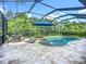 Screened pool area featuring a sparkling pool with a water feature, hot tub, and outdoor dining space at 20749 Swallowtail Ct, Venice, FL 34293