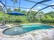 Screened pool area featuring a sparkling pool with a water feature, hot tub, and outdoor dining space at 20749 Swallowtail Ct, Venice, FL 34293
