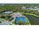 Aerial view of tennis courts surrounded by lush landscaping, a community center, and a parking lot at 21641 Winter Park Ct, Venice, FL 34293