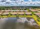 Beautiful waterfront homes with tile roofs surround a serene lake, offering stunning views and a peaceful setting at 21641 Winter Park Ct, Venice, FL 34293