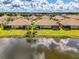 Aerial view of stunning homes overlooking tranquil lake, with lush greenery and beautiful tile roofs at 21641 Winter Park Ct, Venice, FL 34293