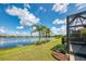 Picturesque backyard featuring a tranquil lake view and lush landscaping with palm trees at 21641 Winter Park Ct, Venice, FL 34293