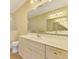Bright bathroom featuring a large mirror, vanity, toilet, and shower with glass doors at 21641 Winter Park Ct, Venice, FL 34293