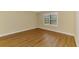 An empty bedroom showcasing hardwood floors, a window with blinds, and neutral-colored walls at 21641 Winter Park Ct, Venice, FL 34293