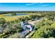 Aerial view of the community entrance featuring mature landscaping, gatehouse, and a glimpse of the picturesque lake at 21641 Winter Park Ct, Venice, FL 34293