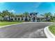 Attractive exterior elevation with palm trees, elegant stone accents, a paved driveway, and blue shutters at 21641 Winter Park Ct, Venice, FL 34293