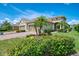 Beautiful front exterior with lush landscaping and a paver driveway leading to a two-car garage at 21641 Winter Park Ct, Venice, FL 34293