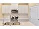 A close-up view of the kitchen, highlighting stainless steel appliances and white cabinets at 21641 Winter Park Ct, Venice, FL 34293