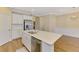 Open kitchen featuring a large center island with sink, stainless steel appliances, and wood floors at 21641 Winter Park Ct, Venice, FL 34293