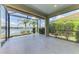 Spacious lanai with a view of the lake, palm trees, and landscaped backyard at 21641 Winter Park Ct, Venice, FL 34293