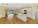 Spacious open concept living area with wood floors, island kitchen, and sliding glass doors to the lanai at 21641 Winter Park Ct, Venice, FL 34293