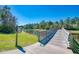Scenic view of a charming community pond and a wooden bridge surrounded by lush greenery at 21641 Winter Park Ct, Venice, FL 34293