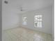Clean, bright bedroom with tile flooring, ceiling fan, and two windows at 2204 L Pavia Blvd # 2204, Venice, FL 34292