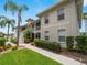 Beautiful condo building with tropical landscaping, sidewalks, and palm trees on a sunny day at 2204 L Pavia Blvd # 2204, Venice, FL 34292