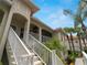 Staircase leading to a condo entrance with white railings and tropical landscaping on a sunny day at 2204 L Pavia Blvd # 2204, Venice, FL 34292