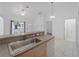 Open kitchen view featuring granite countertop and stainless steel sink at 2204 L Pavia Blvd # 2204, Venice, FL 34292
