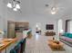 Open living room with tile floors, modern furniture, and a breakfast bar in the kitchen at 2204 L Pavia Blvd # 2204, Venice, FL 34292