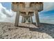 Underneath the pier showing concrete support pillars, sand, and distant ocean views at 2204 L Pavia Blvd # 2204, Venice, FL 34292