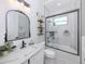 Bright bathroom with tub shower combo, white marble tiling, and white vanity sink at 2245 Pickard Ln, North Port, FL 34286