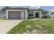 Beautiful home showcasing modern architectural style with a two car garage, manicured lawn and decorative landscaping at 2245 Pickard Ln, North Port, FL 34286